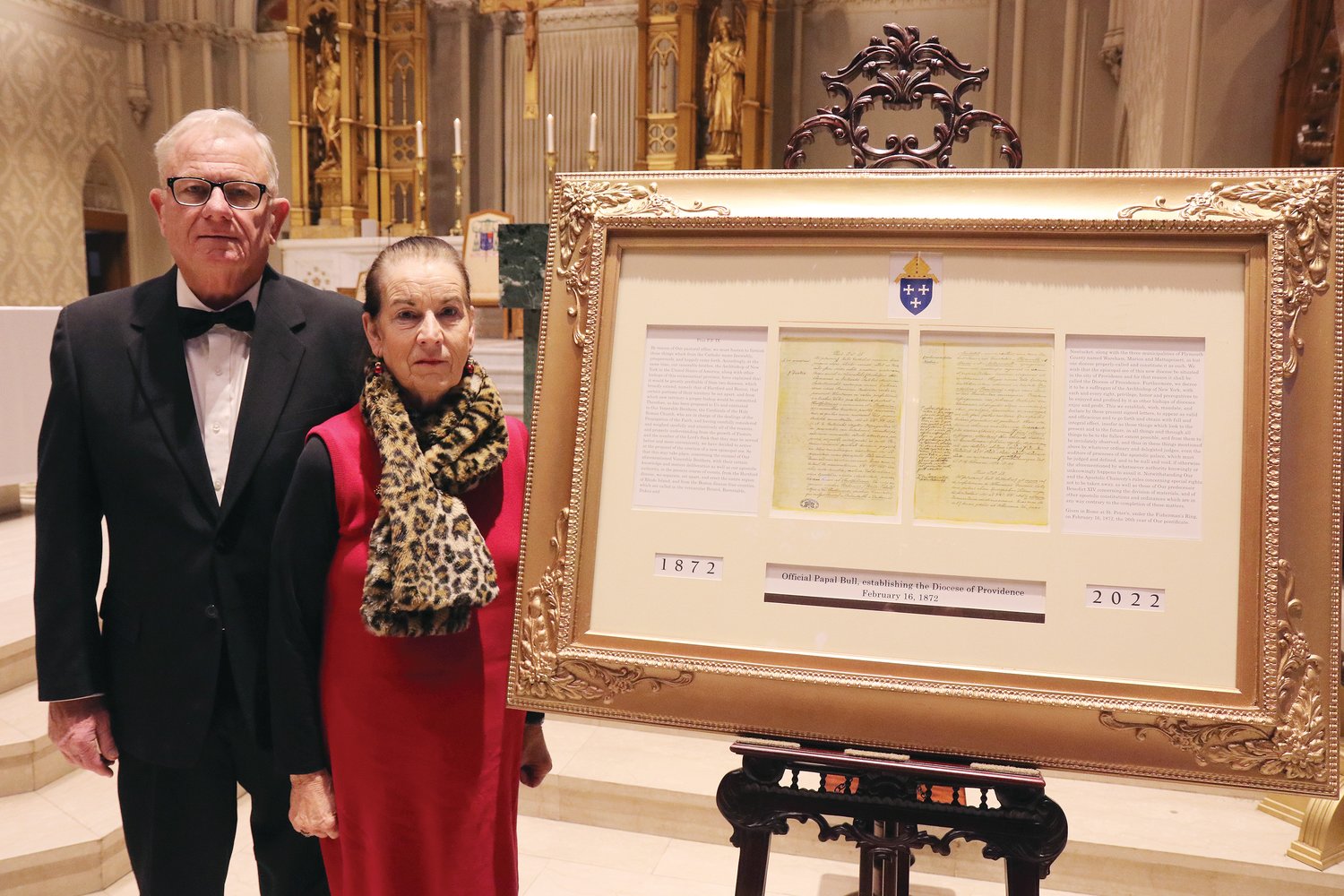 The bishop also acknowledged Thomas H. Lynch, pictured at left with his wife Rose, the artist designer who designed and executed the frame displaying the historical document.